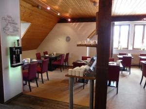 a dining room with tables and chairs and windows at Hotel KRONE Garni in Deckenpfronn
