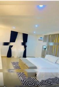 a bedroom with a large white bed in a room at Games village Suites in Abuja