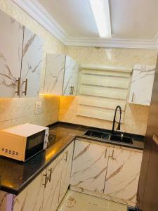 a kitchen with a sink and a microwave on a counter at Games village Suites in Abuja