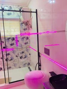 a pink room with a glass wall with a bunch of donuts at Games village Suites in Abuja