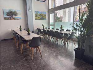 a row of tables and chairs in a room with plants at Paloma in Athens