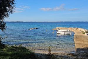 two boats in the water next to a beach at Secluded holiday house Cove Nevidjansko Polje, Pasman - 12806 in Neviđane +10 photos