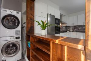 a kitchen with a wooden counter and a washer and dryer at Veigas de Iria - Apartamento Turístico VUT in Padrón