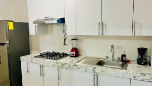 a kitchen counter with a sink and a stove at Relax Depa in Matamoros +4 photos