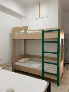 a room with two bunk beds and a ladder at Corinth Beach Apartment and Hostel in Korinthos