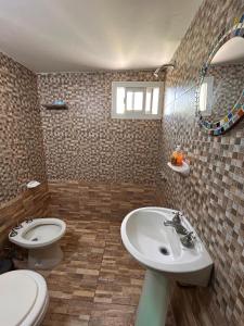 ein Badezimmer mit einem weißen Waschbecken und einer Toilette in der Unterkunft casa de descanso el molino 2 in Cordoba