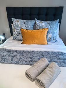 ein Bett mit zwei Kissen und zwei Handtüchern darauf in der Unterkunft Cozy Cottage on 5th Avenue in Johannesburg