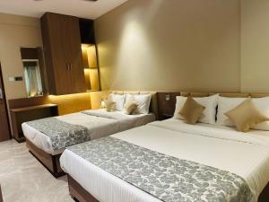 a hotel room with two beds in a room at The Falcon Inn in Mumbai