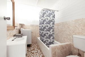 a bathroom with a sink and a shower curtain at Shoalhaven Heads Motel in Shoalhaven Heads