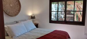 a bedroom with a bed with a window and a pillow at Macondo entre cerros y mar in Piriápolis