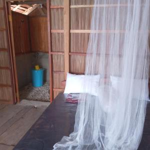 a bedroom with a bed with a mosquito net at Yen Bainut Homestay in Fam