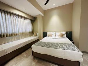 a bedroom with two beds and a window at The Falcon Inn - Mumbai Central in Mumbai