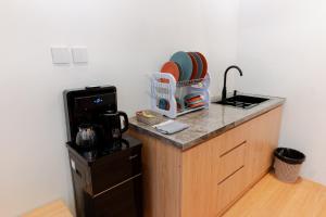 a kitchen with a counter top with a sink at The Sikarim Waterfall View Villa in Kejajar