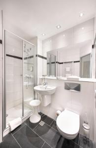 a bathroom with a toilet and a sink and a shower at Hotel am Wald in Monheim