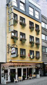 a yellow building with tables and chairs in front of it at Hotel am Museum Köln in Cologne