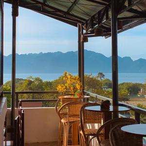 a balcony with tables and chairs and a view of the ocean at Upgrace Inn Coron in Coron