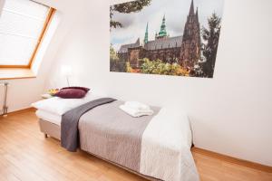 a bedroom with a bed with a painting on the wall at Wenceslas Square Lofts in Prague