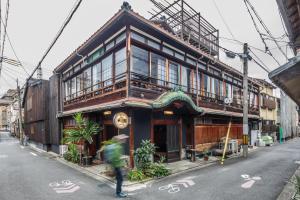a person walking in front of a building at Yadoya Hiraiwa private ryokan in Kyoto