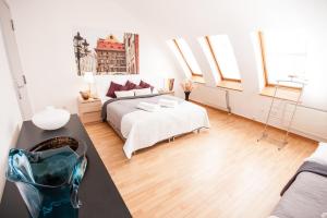 a bedroom with a bed and a room with windows at Wenceslas Square Lofts in Prague