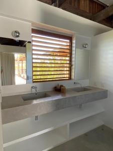 a bathroom with two sinks and a large mirror at Casa Terra in São Miguel do Gostoso +52 photos