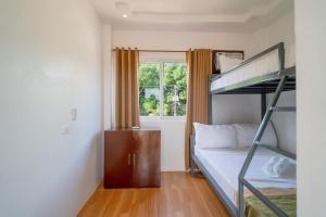 a bedroom with a bunk bed and a window at Upgrace Inn Coron in Coron