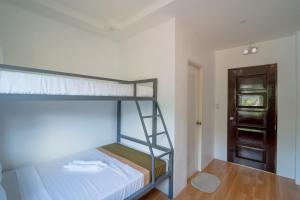 a bunk bed in a room with a wooden door at Upgrace Inn Coron in Coron +13 photos