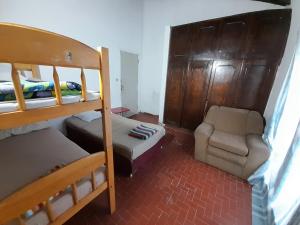 a bedroom with two bunk beds and a chair at Quintana in Asunción