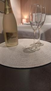 a bottle of wine and two wine glasses on a table at Loft Studio bem localizado e novinho in Passo Fundo