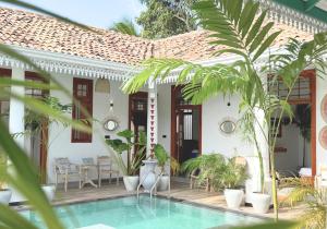 a villa with a swimming pool in front of a house at Marshmellow Surf Camp Sri Lanka in Ahangama