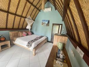 a bedroom with a bed and a table in a room at Apit Lawang EcoLodge Nusa Penida in Sampalan
