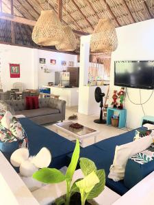 a living room with a couch and a tv at Habitación 4 personas in Moñitos