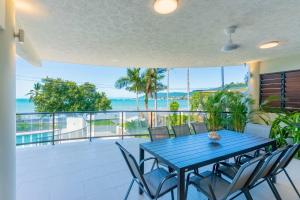 坎农代尔Whitsunday Escape - Beachfront with Private Pool的阳台上的蓝色桌椅