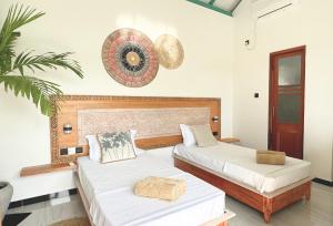 a bedroom with two beds and a fan at Marshmellow Surf Camp Sri Lanka in Ahangama