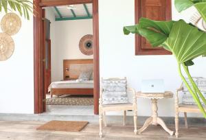 a bedroom with a bed and a table with a laptop at Marshmellow Surf Camp Sri Lanka in Ahangama