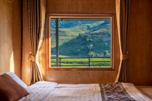 Schlafzimmer mit einem Fenster mit Bergblick in der Unterkunft PaoDzung Homestay Sapa in Sa Pa