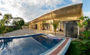 a swimming pool in front of a house at La Laguna in Nosara