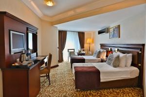 a hotel room with two beds and a desk at Mosaic Hotel Old City -Special Category in Istanbul