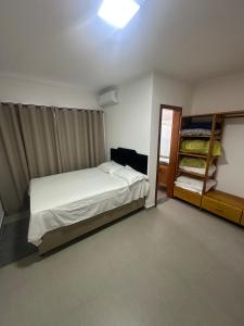 - une petite chambre avec un lit et un placard dans l'établissement Casa de Praia com piscina, à Santa Cruz Cabrália