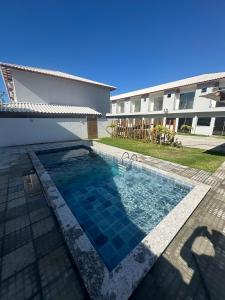 une piscine devant un bâtiment dans l'établissement Casa de Praia com piscina, à Santa Cruz Cabrália