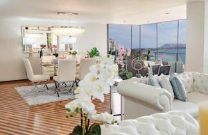 - un salon avec des canapés blancs, une table et des chaises dans l'établissement OceanFront Larcomar Apartments, à Lima