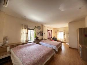 a bedroom with two beds and a window at An Thai Homestay Hue in Hue