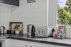 a kitchen counter with a toaster and other appliances on it at Charming 3-Bed Home Near Sunshine Coast in Caloundra West