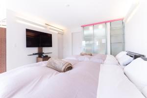 箱根町にあるSmart Villa Hakone Ashinoko-Smart Villa 箱根芦ノ湖の白いベッドルーム(ベッド3台、薄型テレビ付)