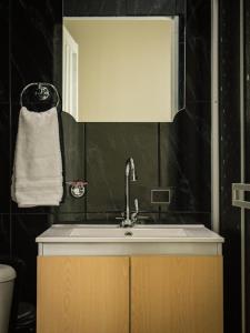 a bathroom with a sink and a black wall at HOTEL PUERTO DULCE - La Virginia in La Virginia +36 photos