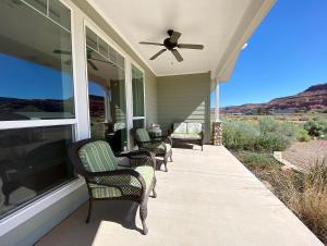 a porch with four chairs and a ceiling fan at Luxury Pet-Friendly Kanab Home Quiet Neighborhood in Kanab