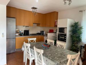 a kitchen with a table with chairs and a table and a kitchen with at OuraSea Apartment in Albufeira
