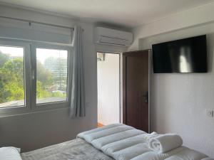 a bedroom with two white beds and a flat screen tv at OuraSea Apartment in Albufeira