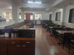 a dining room with tables and chairs in a restaurant at Atithi farmhouse in Alibaug