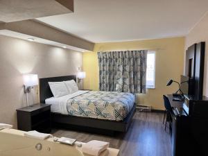 a bedroom with a bed and a window and a tub at Motel 6-Eau Claire, WI in Eau Claire +22 photos