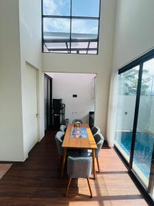 a living room with a wooden table and chairs at Embun Pagi villa - Habitat 110 in Batu